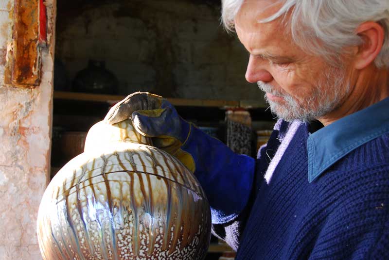 John Dermer inspecting newly fired pots